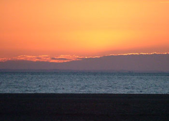 The sun setting over the sand