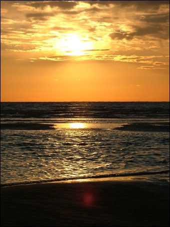The sun setting over the sand